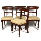 A set of four early 19th century mahogany dining chairs on turned front supports and upholstered