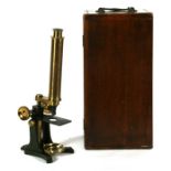 A lacquered brass microscope in a mahogany carry case, 33cms (13ins) high.