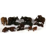 A pair of carved hardwood water buffalo on stands, 19cms (7.5ins) wide; together with two similar