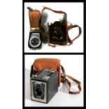 A Bilora Boy maroon Bakelite camera; together with a Kodak Brownie box camera and a Leningrad 4