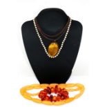 A pearl necklace with silver clasp; together with amber like bead necklaces.