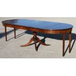 A reproduction mahogany extending drum table with three extra leaves, on turned column and