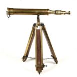 A brass spotters telescope 46cms (18ins) long mounted on an adjustable brass and wood