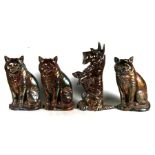A group of cast iron fire side companions, three modelled as cats and one as a dog, 33cms (13ins)