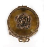 A circular pierced gilt metal trinket box with applied rose to the cover, 8cms (2.1ins) diameter.