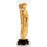 A late 19th / early 20th century Chinese carved ivory figure depicting a robed maiden holding a