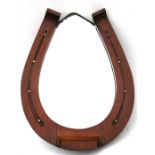 An Edwardian oak framed mirror in the form of a horse shoe, 38cms (15ins) wide.