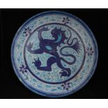 A late 19th / early 20th century pottery charger decorated with a central rampant lion within a