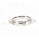 An 18ct white gold modern design ring set with a single diamond, approx UK size 'L'.