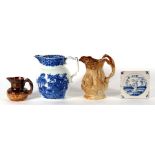 Two stoneware hunting jugs; a blue & white jug; and a Delft tile (4).