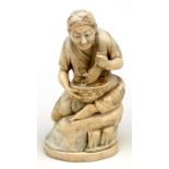 A Japanese Meiji period carved ivory figure in the form of a seated man holding a fish, 11.5cms (4.