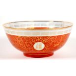 A Chinese bowl decorated with gilded characters and foliate scrolls, on a red ground, 26cms (10.