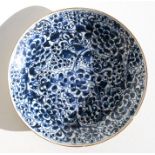 A Chinese Kangxi blue & white shallow dish decorated with flowers, 28cms (11ins) diameter.