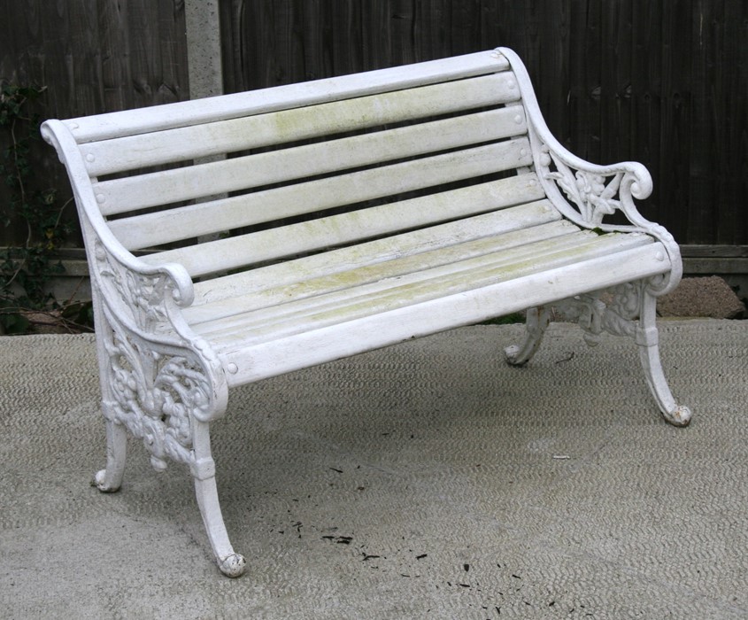 A white painted cast iron garden bench with wooden slatted seat, 116cms (45.75ins) wide.