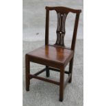 An early 19th century oak country hall chair with pierced splat and square legs.