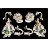 A pair of German porcelain twin arm candle sconces decorated with flowers and surmounted with