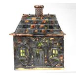 An early 19th century Whieldon glazed box n the form of a cottage, 17.5cms (7ins) wide.