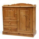 A modern pine cupboard with an arrangement of two cupboards and two short drawers, on plinth base,