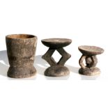 An African tribal carved wooden stool, 19cms (7.5ins) high; together with another smaller similar,