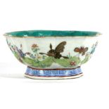 A Chinese famille rose bowl decorated with butterflies and flowers in enamel colours, red seal