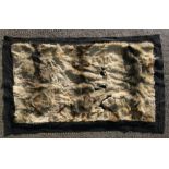 A goatskin/fur rug, 100 by 150cms (39.5 by 59ins).