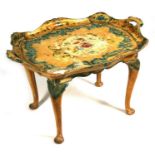 A painted wooden tray table decorated with foliate scrolls, 28cms (32.75ins) wide.