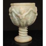 A Romanesque green hardstone goblet carved in relief with a band of nymphs holding grapes, the