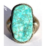 A large Navajo Native American white metal turquoise mounted bangle, initialled to the underside,