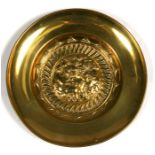 A large brass charger with embossed tavern scene, 51cms (20ins) diameter.