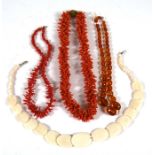 A faceted amber bead necklace, the largest bead 22mm (0.86ins) wide; together with a coral necklace;