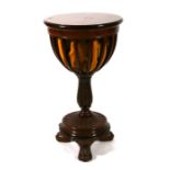 A walnut work table, the circular swivel top enclosing a fitted interior, on carved and turned