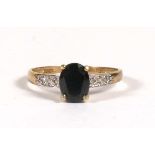 A 9ct gold dress ring set with a central oval sapphire and diamond shoulders, approx UK size 'O'.
