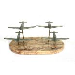 A flight of four identical WW2 cast aluminium fighter aircraft mounted on a marble base. The