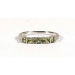 A 9ct gold white gold half eternity ring set with five pale green stones, approx UK size 'N'.