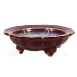 A Chinese aubergine & turquoise glazed shallow bowl standing on three legs, 15cms (6ins) diameter.