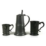 A large 19th century pewter lidded tankard with London touch marks; together with a pewter quart and