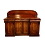 A Victorian figured mahogany sideboard with raised back above three cushion drawers and cupboards