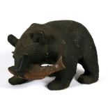 A large Black Forest style carved wooden bear holding a salmon in its jaws, 31cms (12.25ins) long.