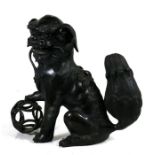 A Chinese bronze censer in the form of a seated fo dog, 31cms (12.25ins) high.