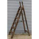 A Victorian Simplex seven-tread pine folding step ladder with shaped iron hinges and iron cross