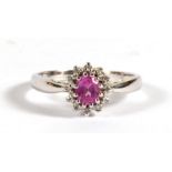 A 9ct white gold cluster ring set with a central pink stone surrounded by diamonds, approx UK