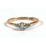 An 18ct gold diamond ring set with a central diamond with four further diamonds to the shoulders,