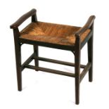 An Art and Crafts walnut rush seated piano stool, 49.5cms (19.5ins) wide.