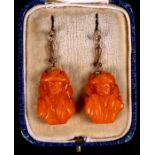 A pair of yellow metal mounted amber drop earrings in the form of a Chinese man, 4.5cms (1.75ins)