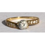 A 9ct gold dress ring set with a large central cubic zirconia and further stones to the shoulders,