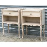 A pair of French style distressed painted bedside cabinets, 50cms (19.75ins) wide.