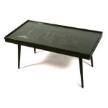 A Chinese hardwood coffee table with glass top, carved with a landscape depicting pagodas in a