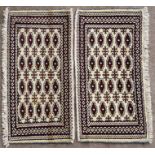 A pair of Persian Baluch woollen handmade rugs with geometric design on a cream ground, each 105