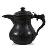An Islamic copper coffee pot engraved with flowers and having a serpent handle, 17cms (6.75ins)