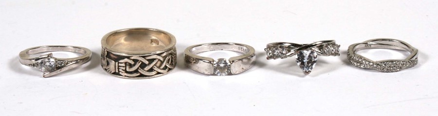 Five silver dress rings.